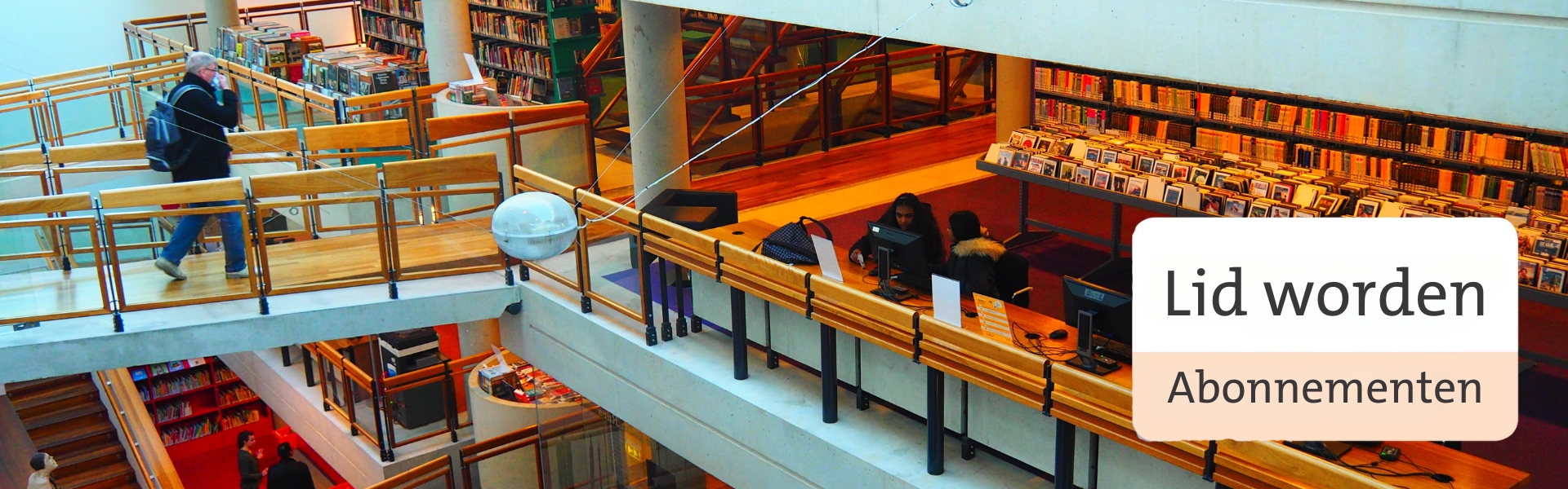 Man loopt de Bibliotheek Bibliorura binnen. Er staan boekenkasten met boeken en bakken met dvd's. Er zitten mensen achter de publieks pc's.